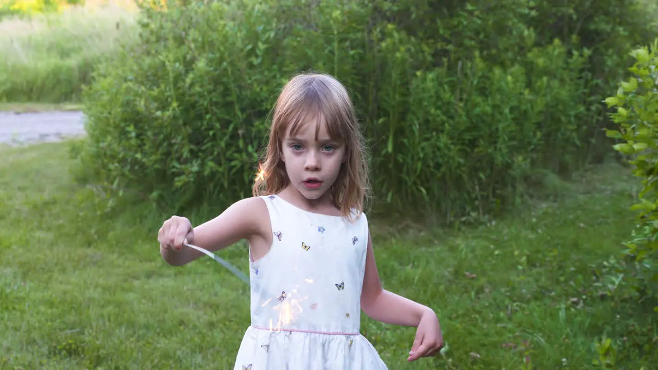 Little girl playing with a sparkler on a summer evening