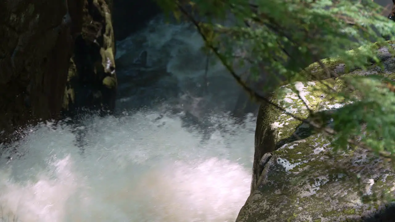 Close up of the spray of a forest waterfall in slow motion