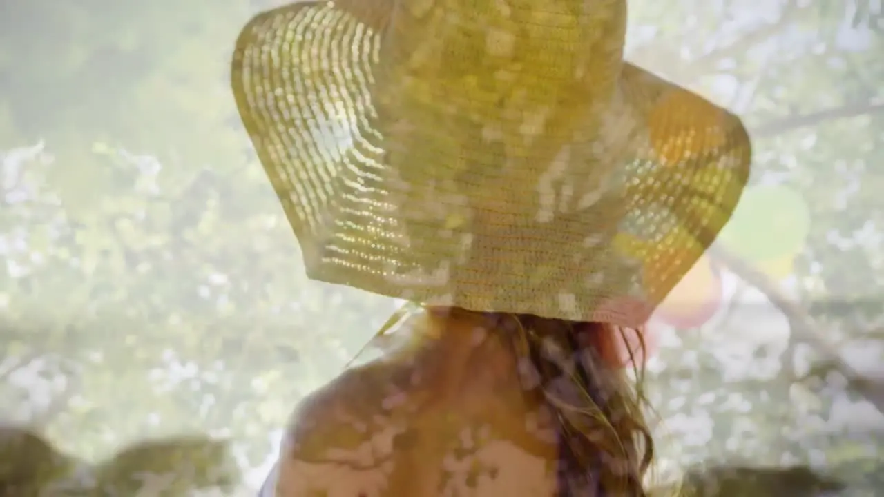 Composite video of rear view of woman wearing a hat against tall trees