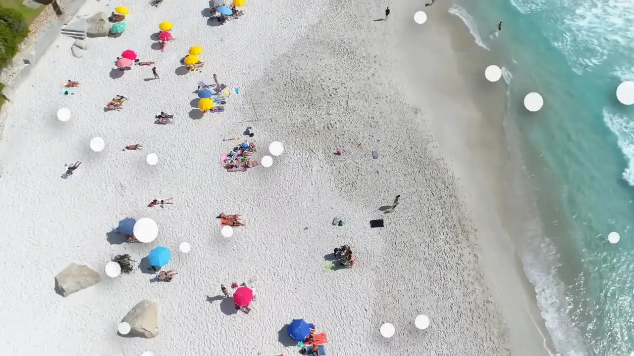 Digital composition of multiple white spots floating against aerial view of the beach