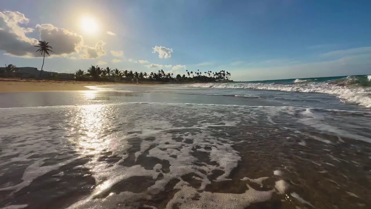 sunset at the beach in Punta Cana Dominican Island of Hispaniola with palm trees on the background and rolling waves on a sandy beach