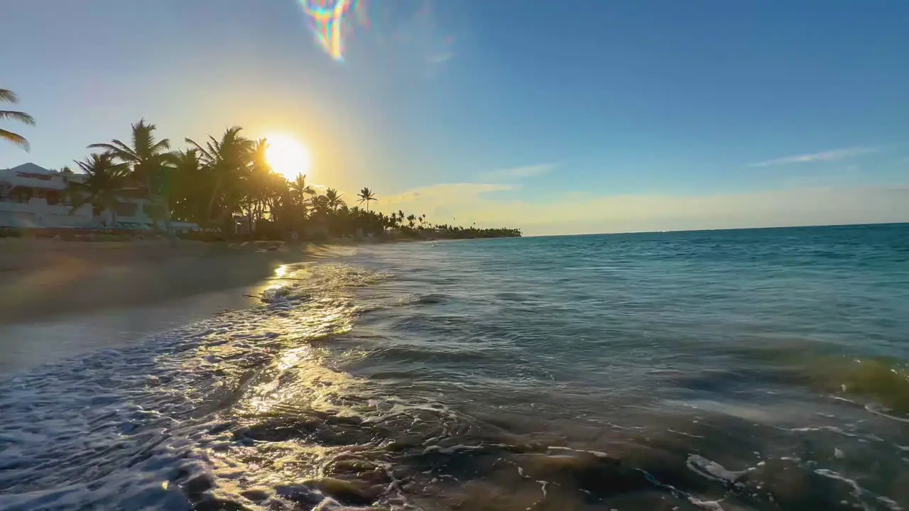 the setting sun reflecting off the rolling waves on the shore of Punta Cana Dominican island of Hispaniola