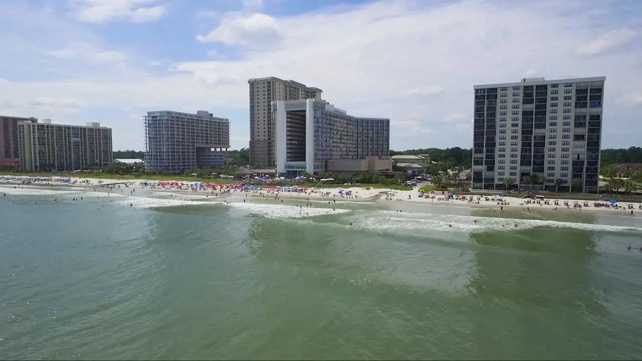 Drone flying low above the water on a sunny day in the summer near a beach