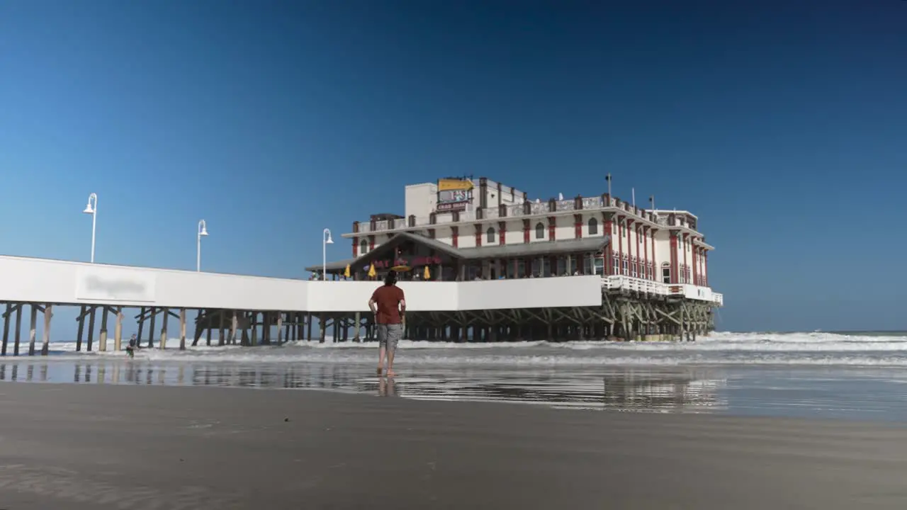 People enjoying the day at the beach near the pier