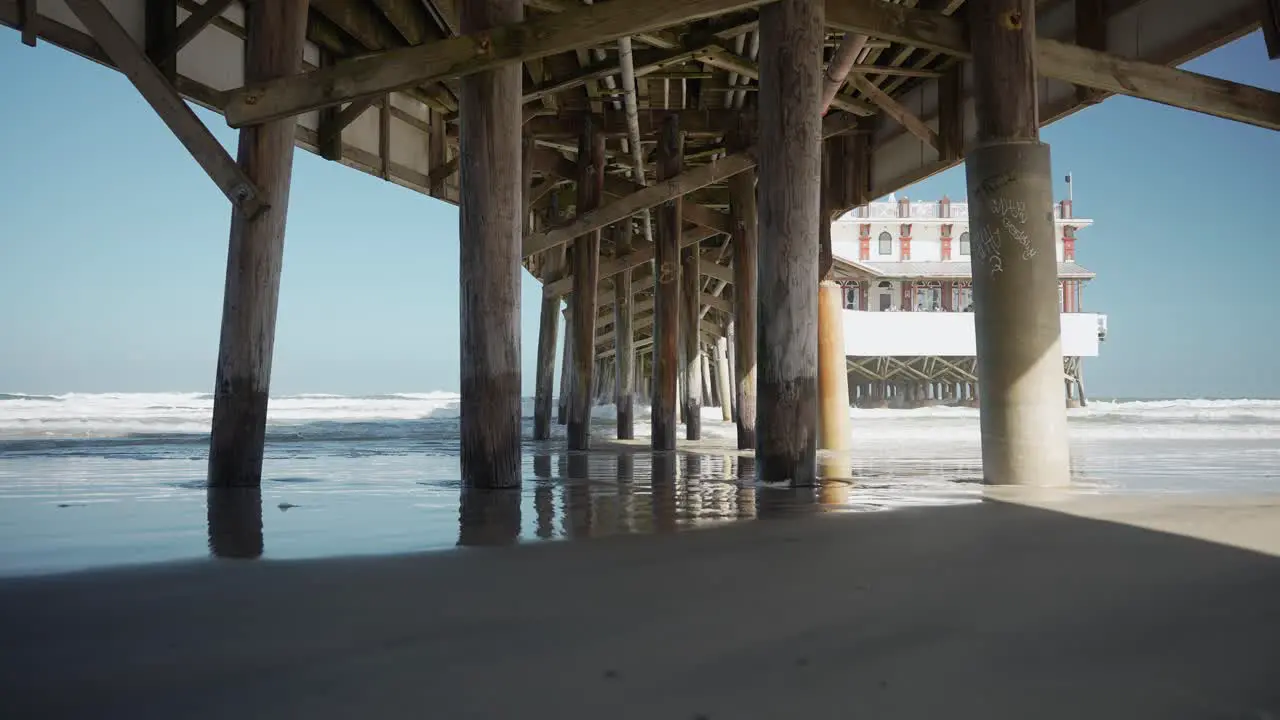 Under the pier people walking waves crashing on the pier