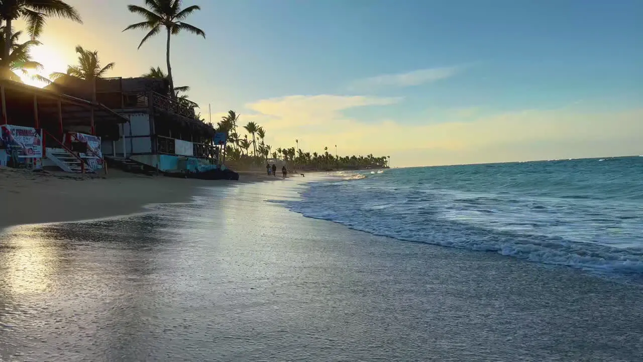 waves rolling to the doorstep of the primitive beach shops at high tide on Punta Cana Dominican Hispaniola island