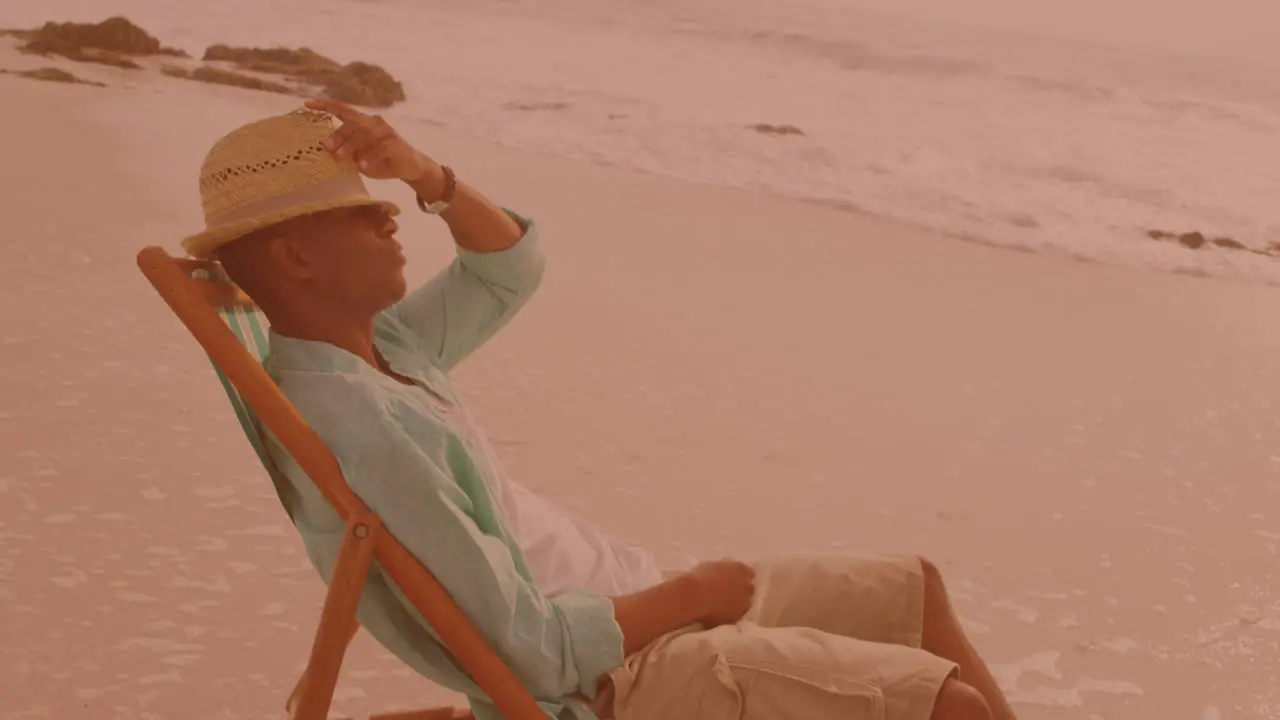 African american man sitting on the chair and relaxing at the beach