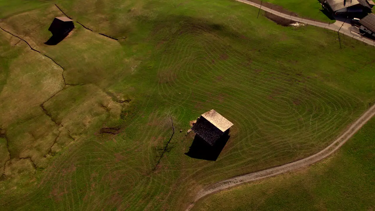 aerial drone footage panning down revealing springtime tractor lines on an alpine field