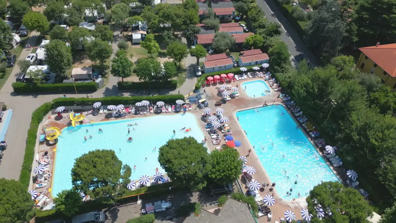 Aerial Shot Orbiting Swimming Pool with People in Camping Cisano San Vito at Lake Garda Italy