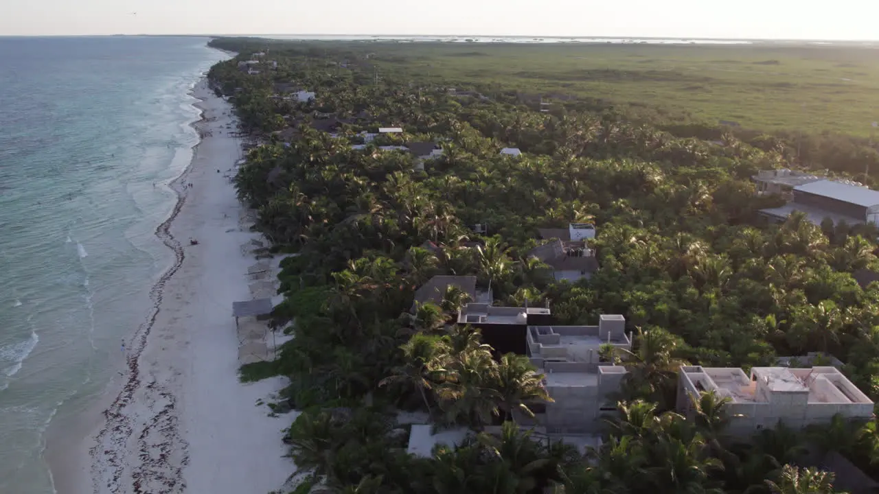 Aerial orbit around houses and resorts on beach in Tulum Cancun Mexico