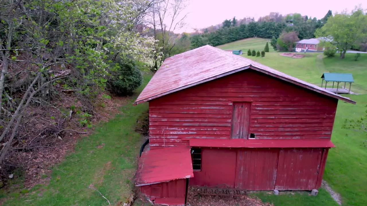 aerial slow push into red barn on farm near boone nc