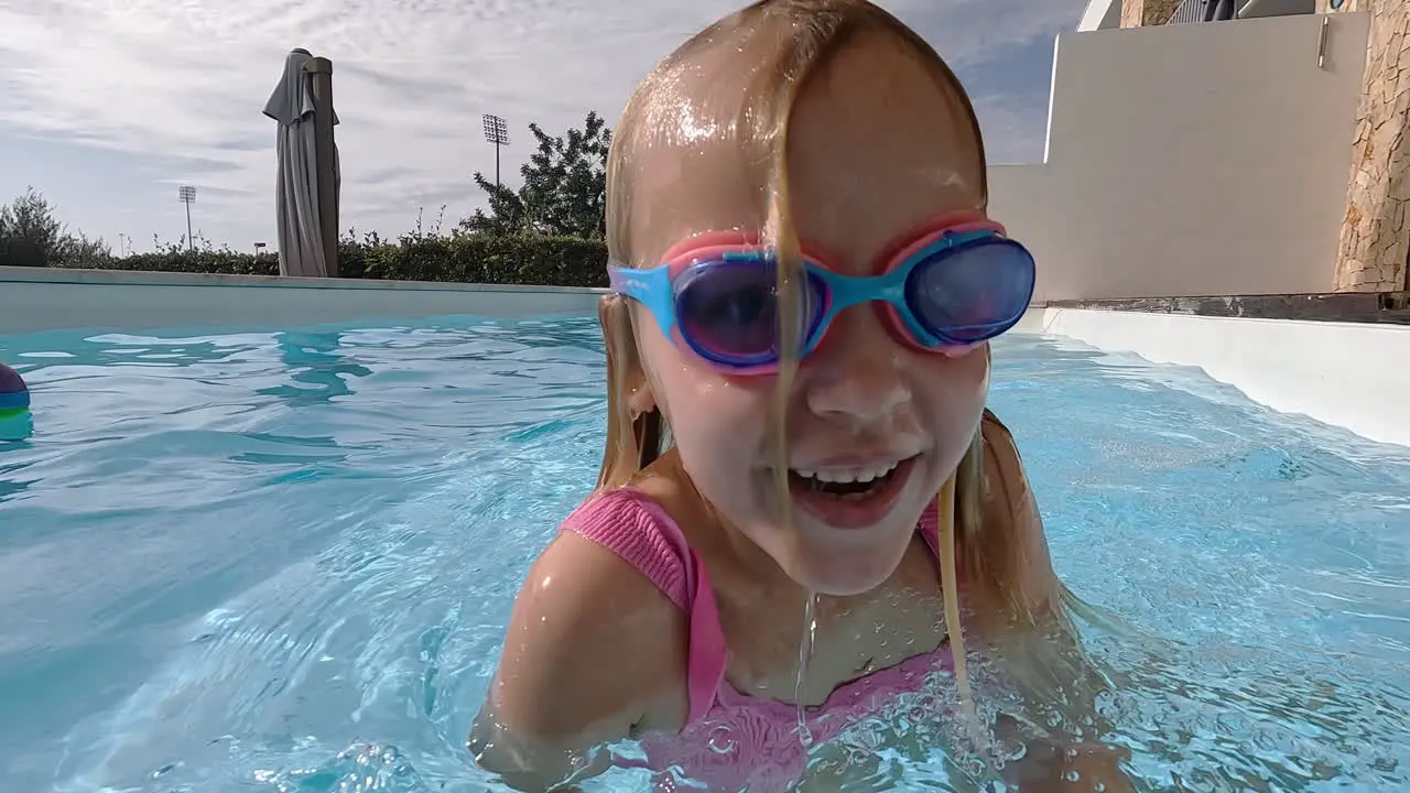 Girl playfully splashing pool water