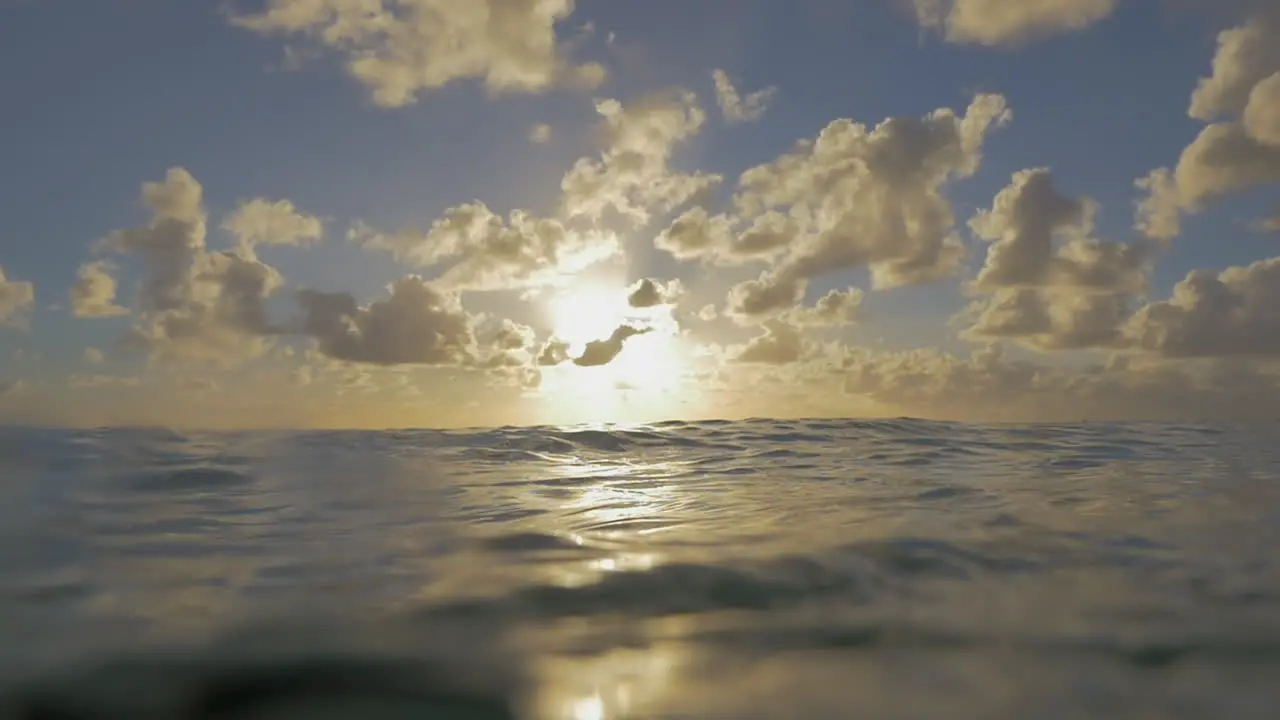 Waving sea water and sunset in cloudy sky