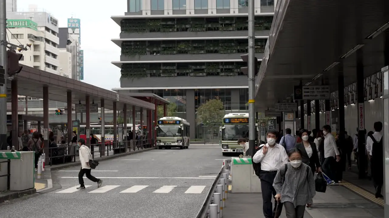 Locals And Commuters Crossing Road At Hiroshima Bus Station Terminal In The Afternoon