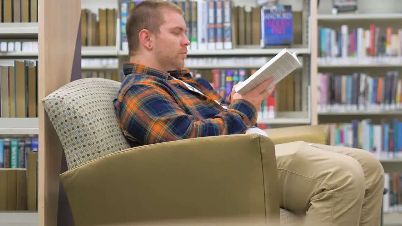 Man sits in the library reading a book