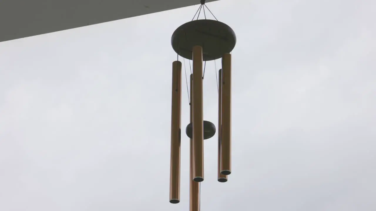 Tilt up close up of wind chimes on a cloudy day