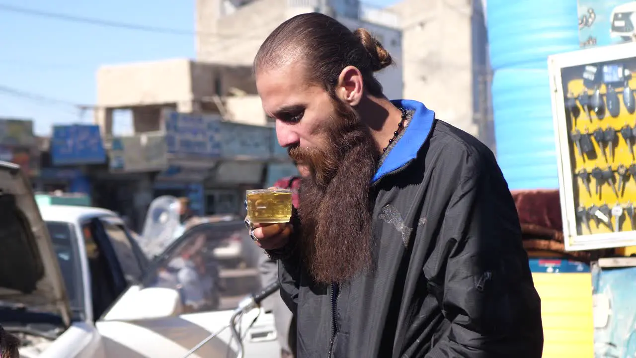 Pakistani Male With Long Beard Blowing On Hot Beverage In Street In Quetta