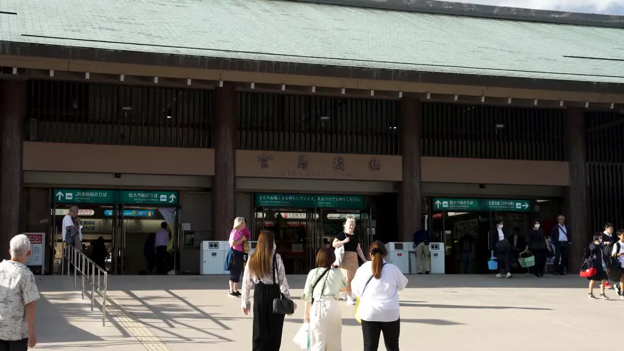 Tourists Walking Towards Miyajima Matsudai Kisen Ferry Terminal Building On Sunny October Day