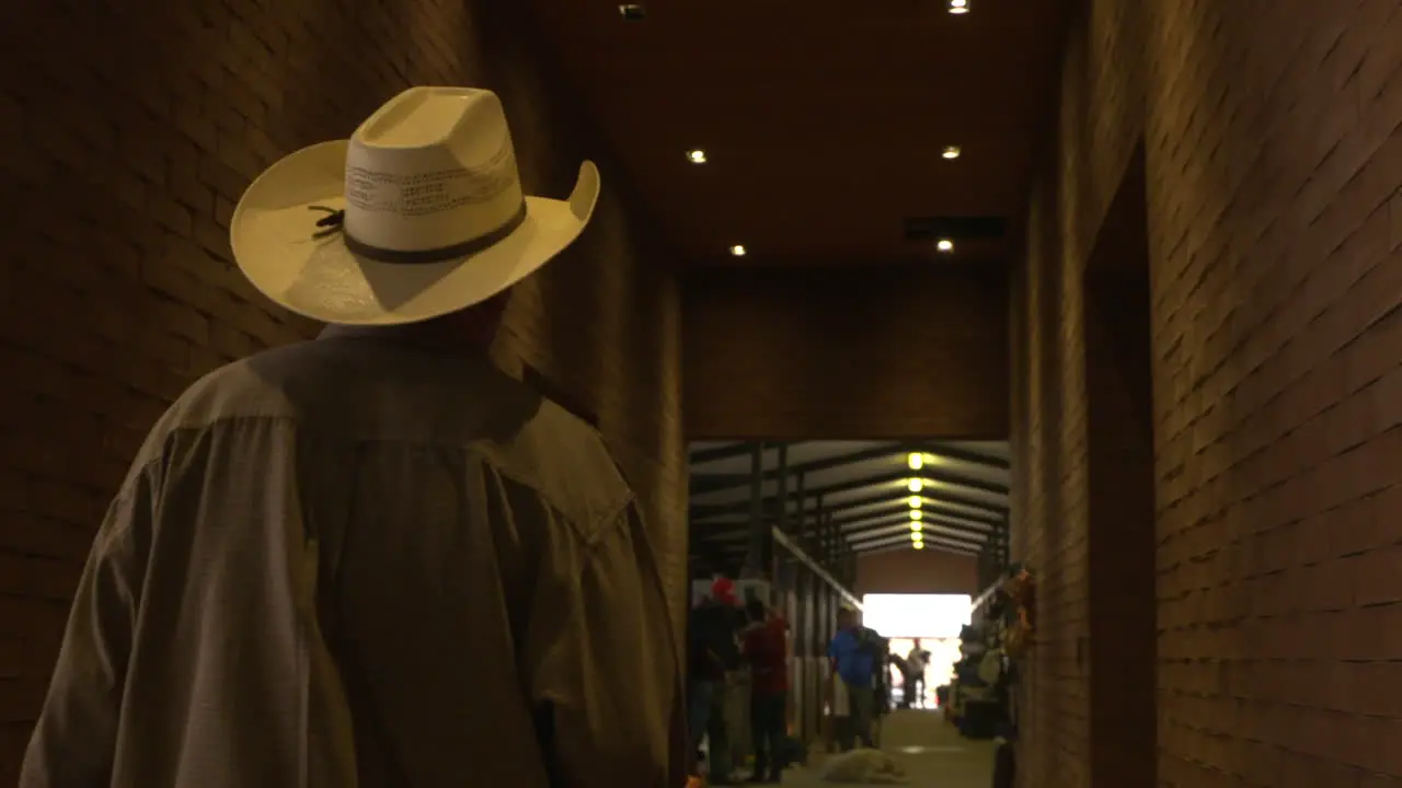 A Mexican groom walks through the extensive stables at a horse show