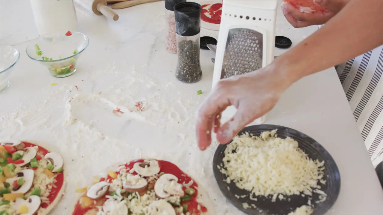 Hands prepare pizza toppings in a home kitchen