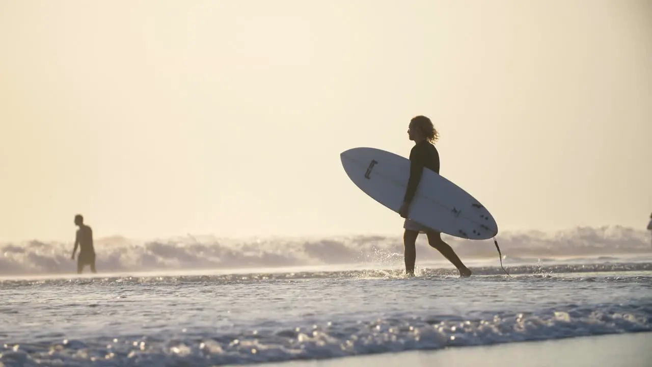 Man Walking into the Sea with a Surfboard