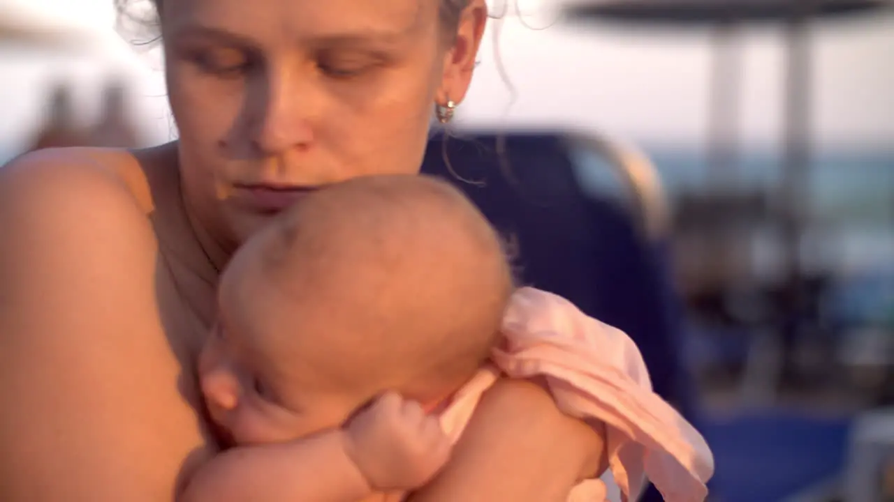 Mum with baby on the beach at sunset