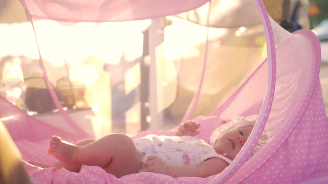 Baby lying in pink bassinet outdoor