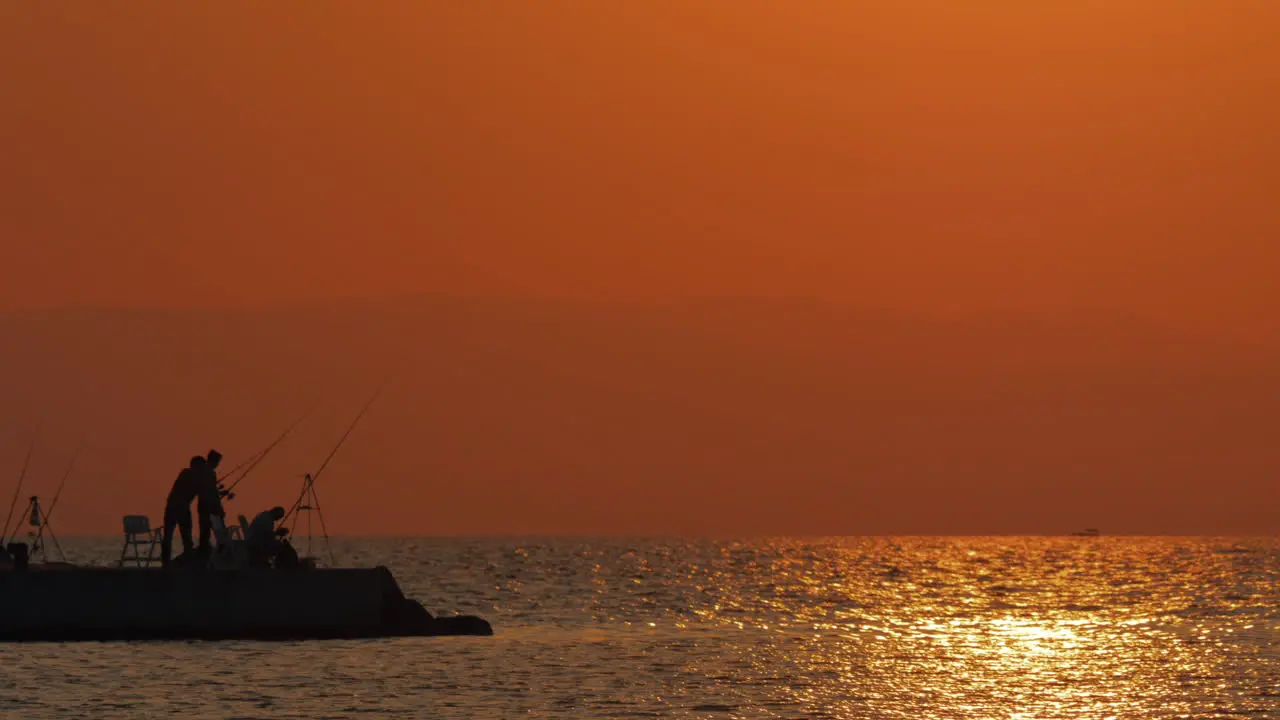 Evening scene of sea and fishermen on the pier