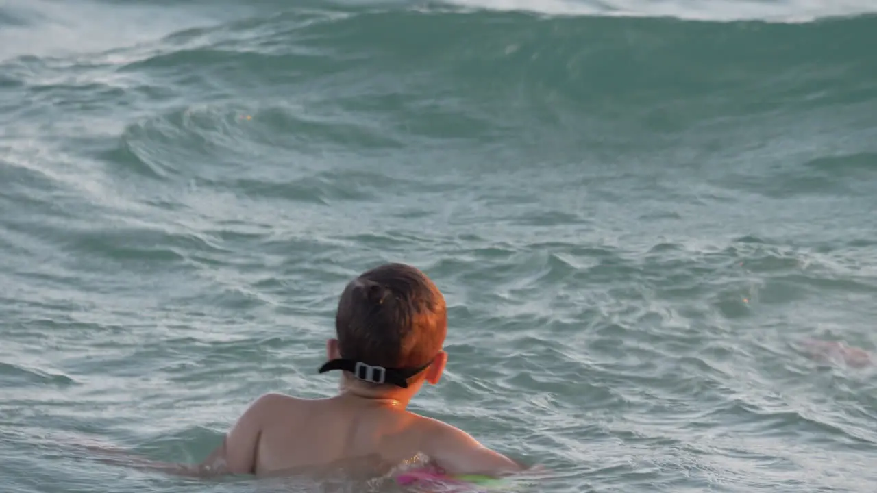 Child is happy to swim on sea waves