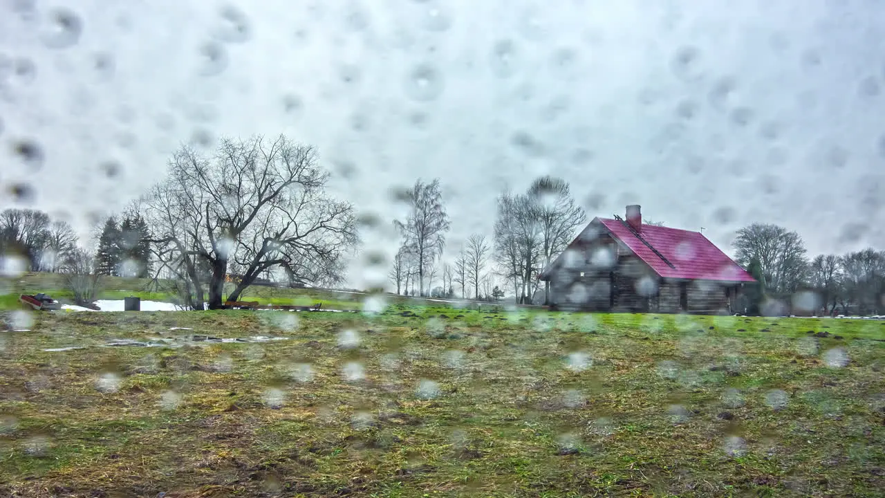 Time lapse of rural house on grass field moving clouds during day over rainy drops overlay