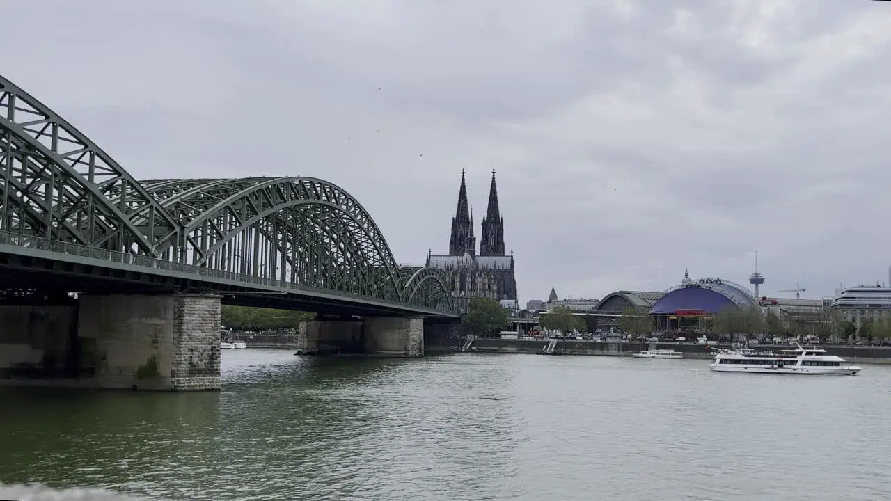 Cologne cathedral with Holzholand bridge and Rhine in the foreground with main train station on the river in good weather