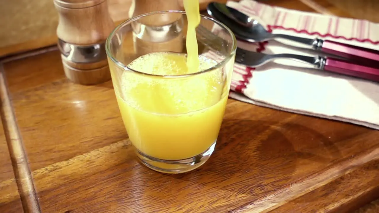 Orange juice pouring into a glass the morning Breakfast Slow motion with rotation tracking shot