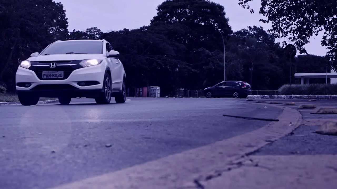 Cars driving on roundabout in Brazil in slow motion desaturated gloomy effect