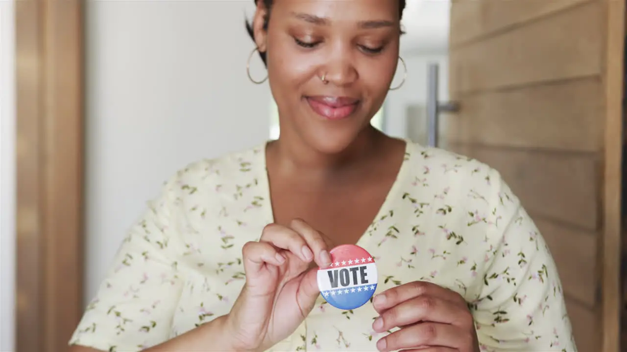 Young biracial woman pins a 'VOTE' badge on her top