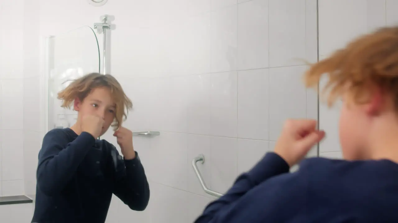 Teenager boxing in slowmo in bathroom mirror