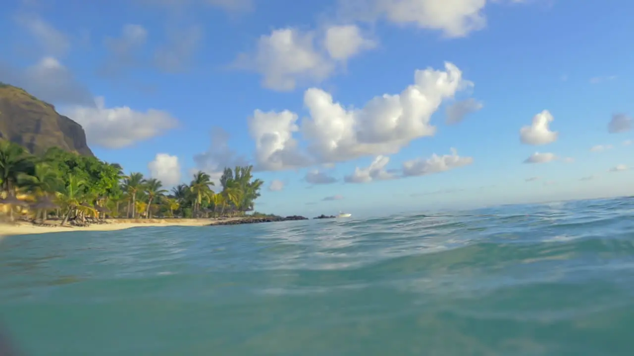 Bathing in clear blue ocean with view to tropical beach