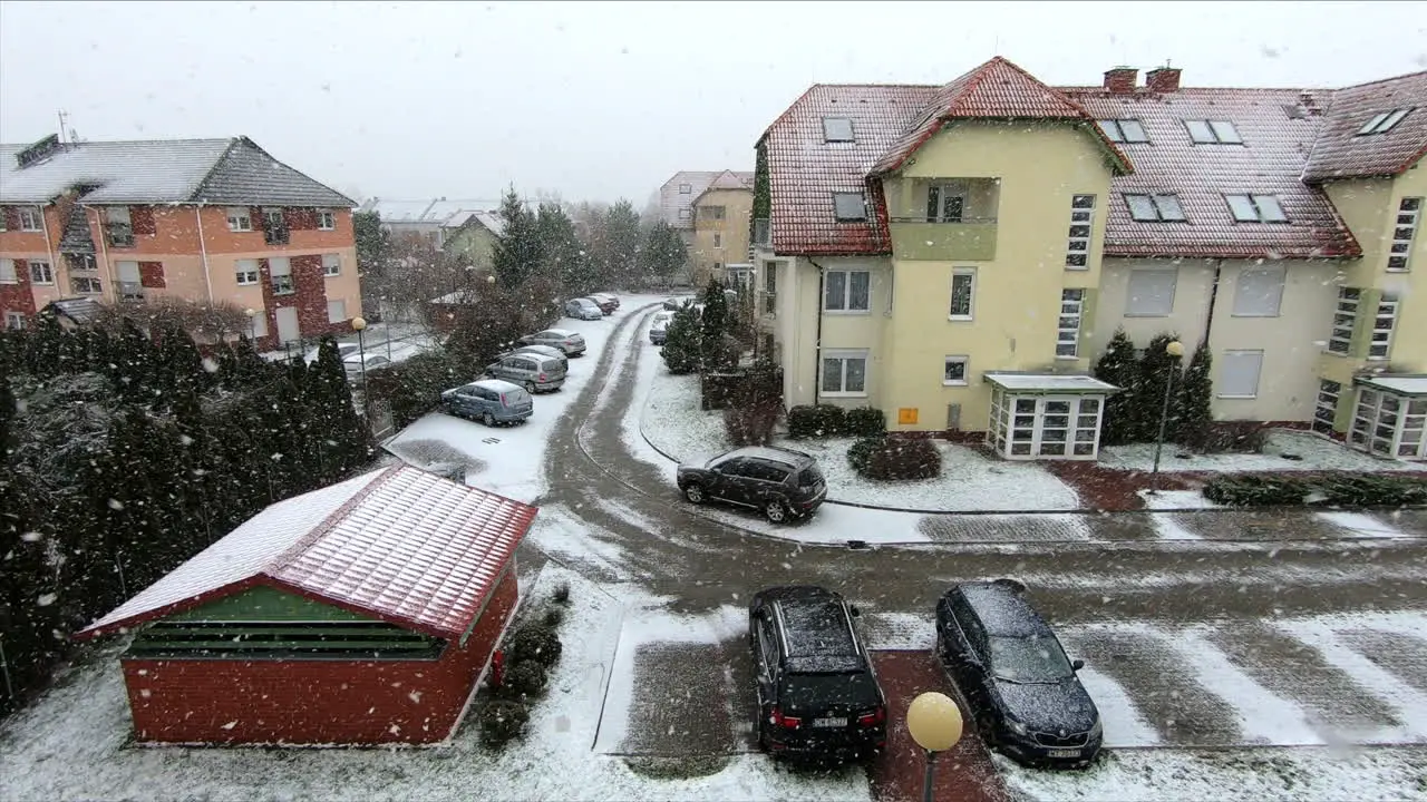 Slow motion shot of snow falling in a city suburb