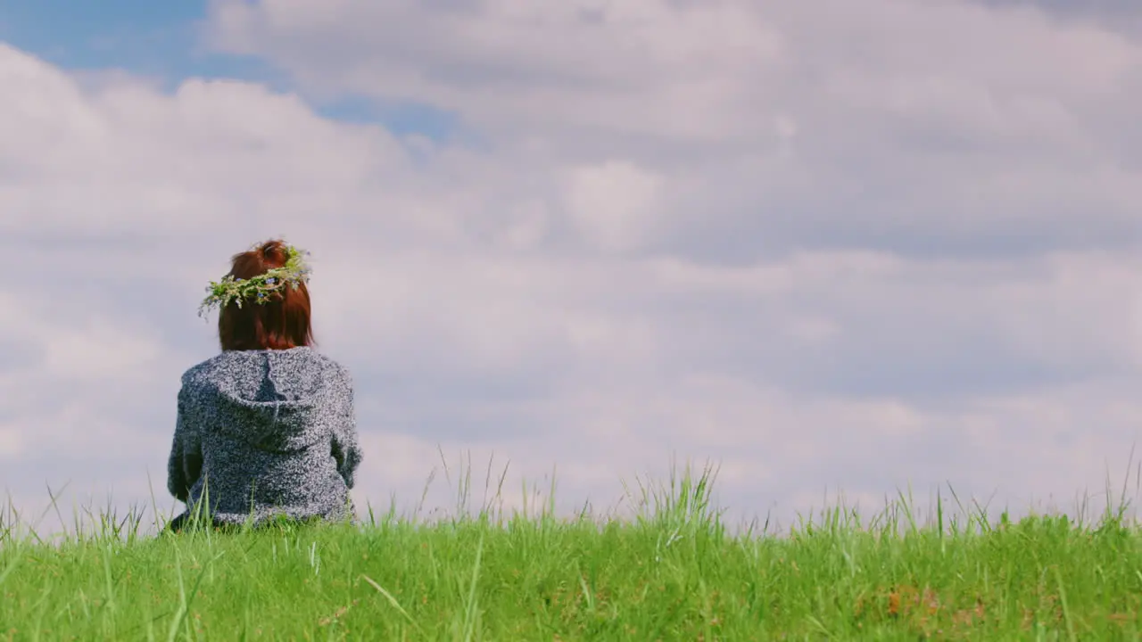 A Lonely Woman Is Sitting On A Green Hill