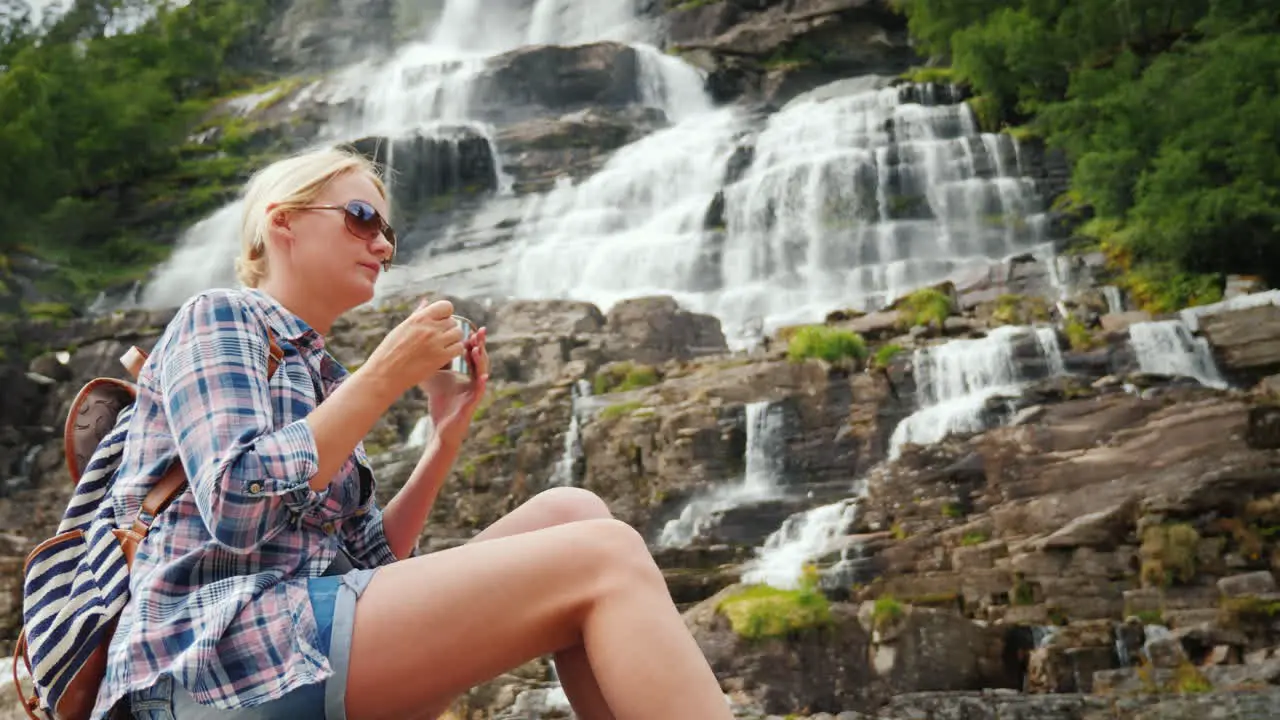 Young Woman Drinks Water On The Background Of The Twin Waterfall Tvindefossen In Norway Clean Drinki