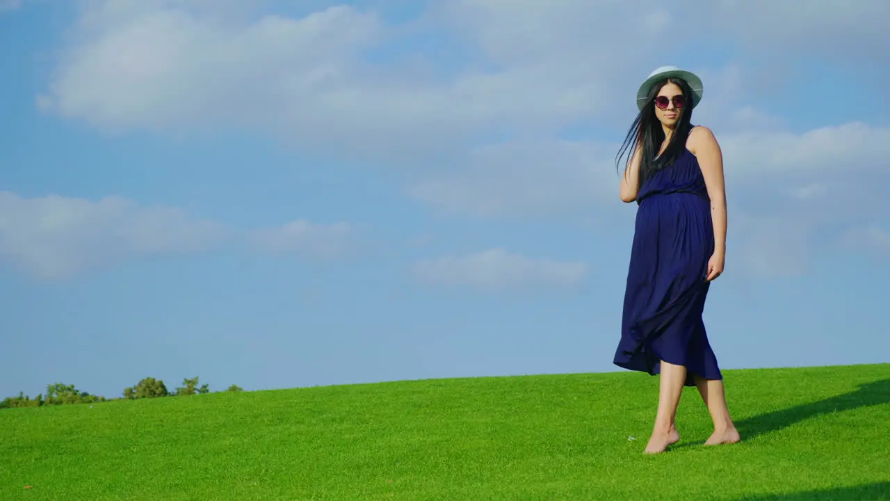 Happy Pregnant Woman Is Walking In The Park Smiling 1