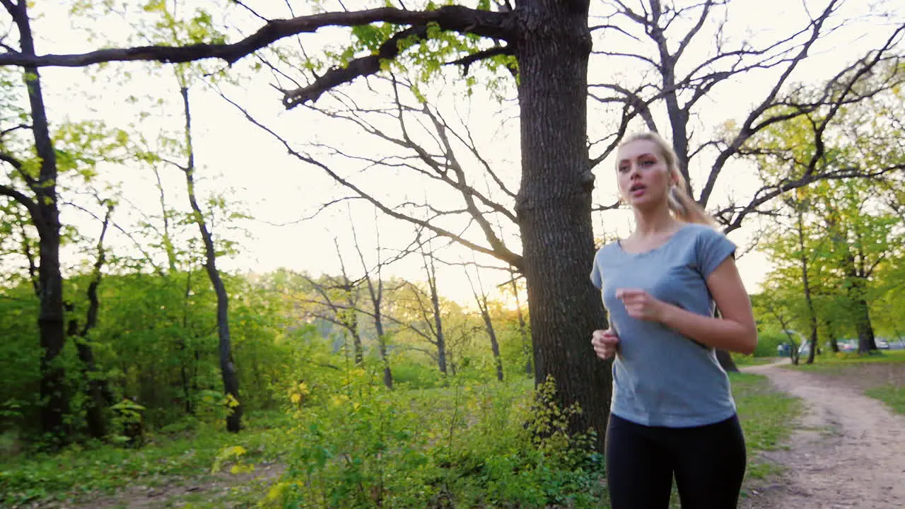 Beautiful Woman In T-Shirt Makes A Run In The Spring Forest Steadicam Shot