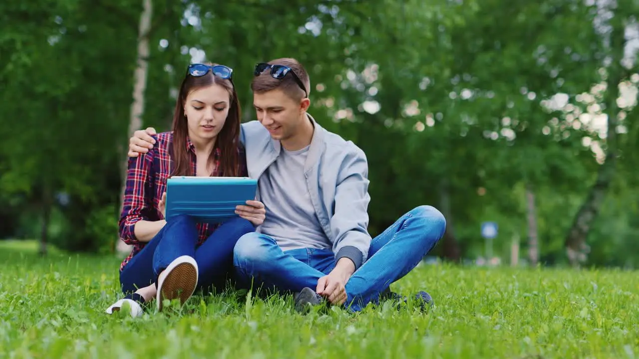 Young Girl And A Guy Used A Tablet In The Park Boy Embraces Girl Hd Video