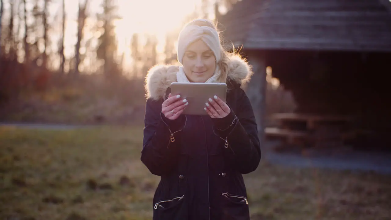 Wireless Technology Woman Using Digital Tablet In Park In Autumn 1