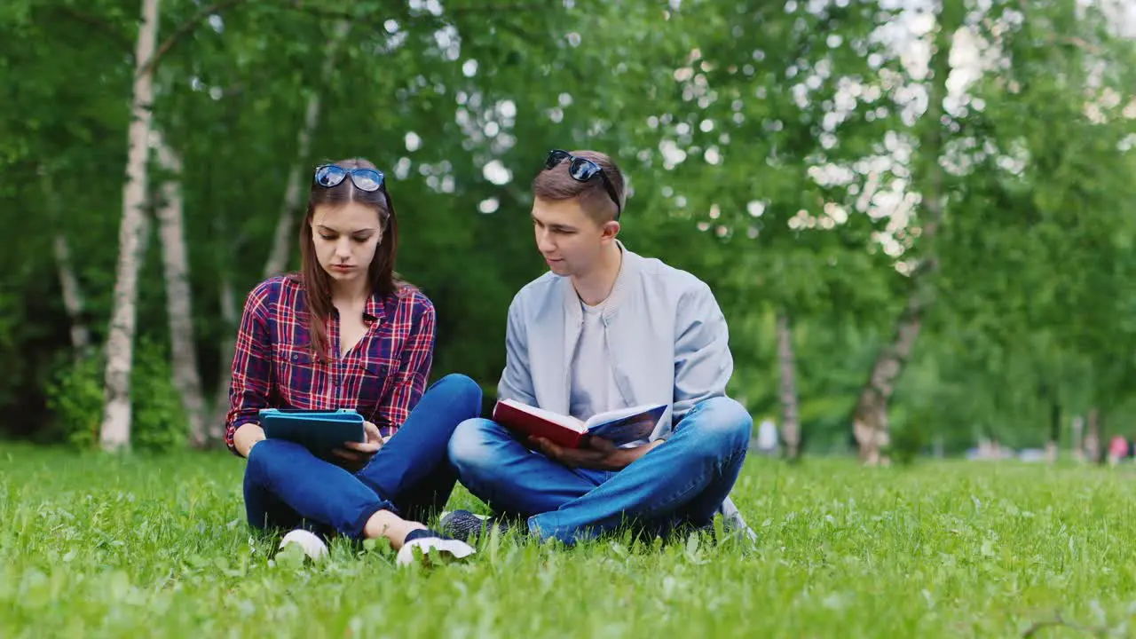 Students Sitting On Grass in Park