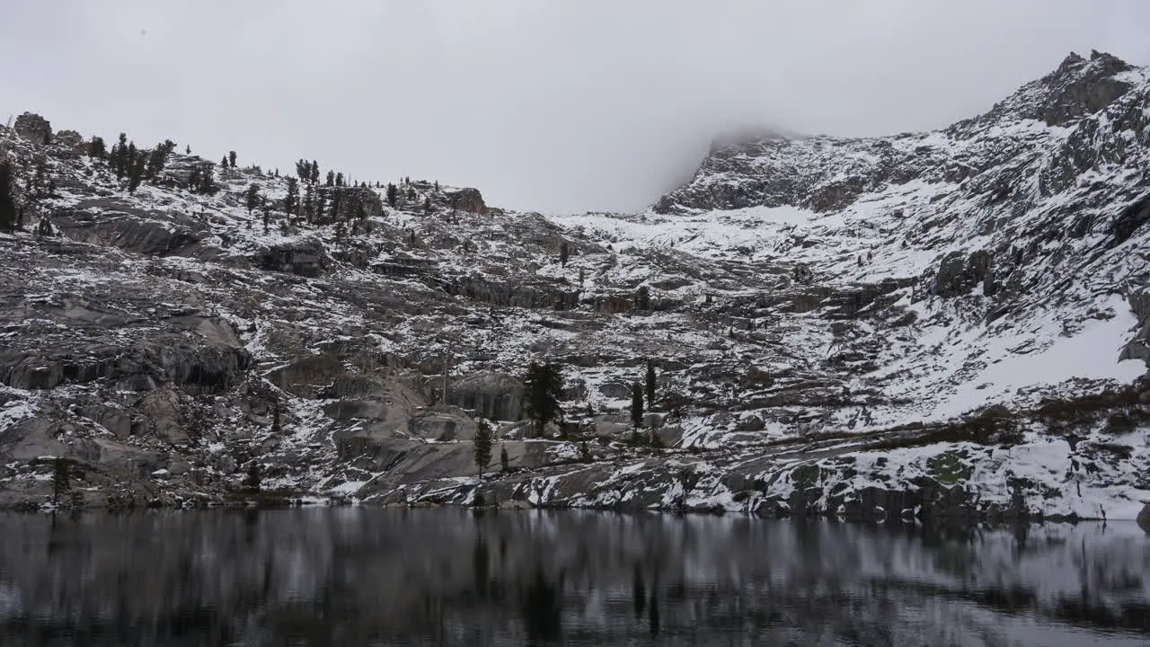 Thick Low Clouds Pass Over Alpine Peak and Lake Timelapse