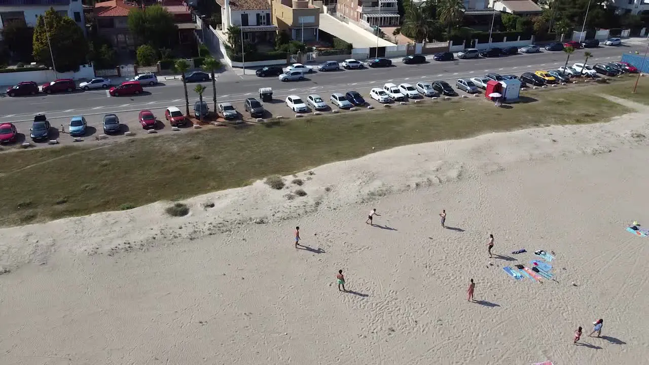 Group of friends playing frisbie on a beach in Spain