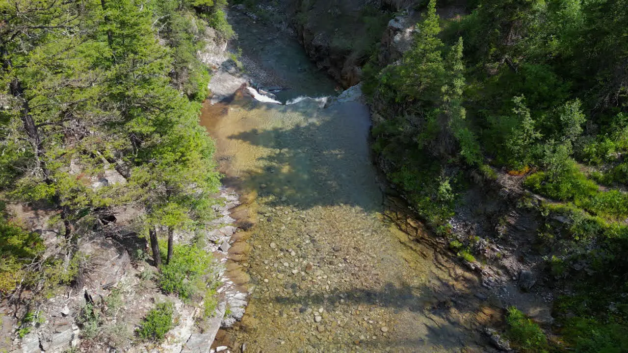 Flying Down a River Waterfall into Forest Canyon