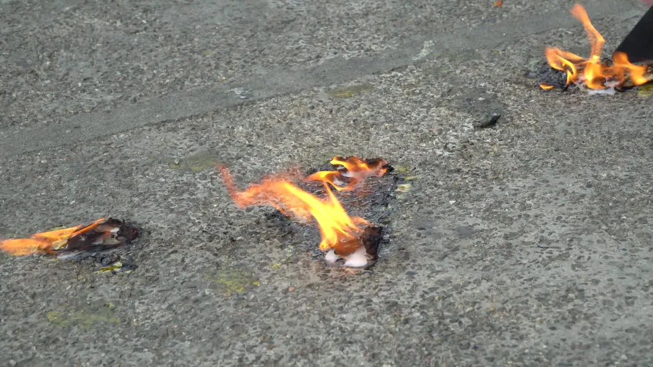 Removing paint on asphalt with fire on the street in Thailand