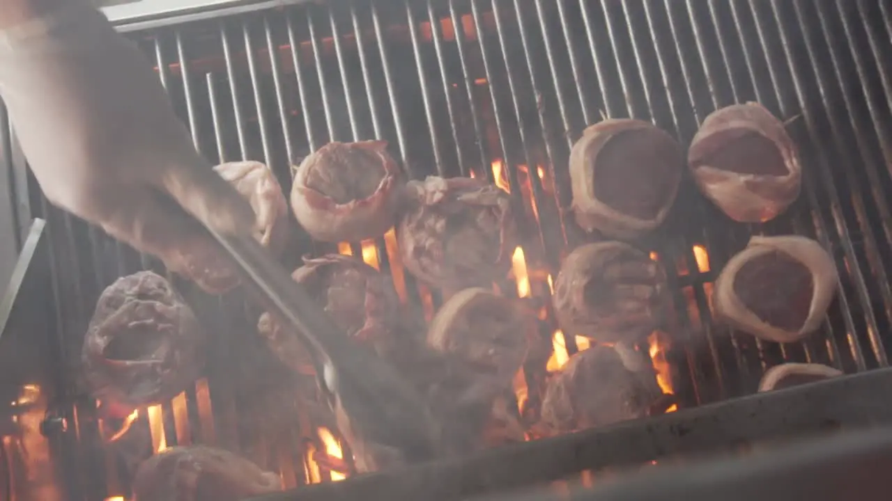 A filet mignon grilled while bacon burning fat in slow motion