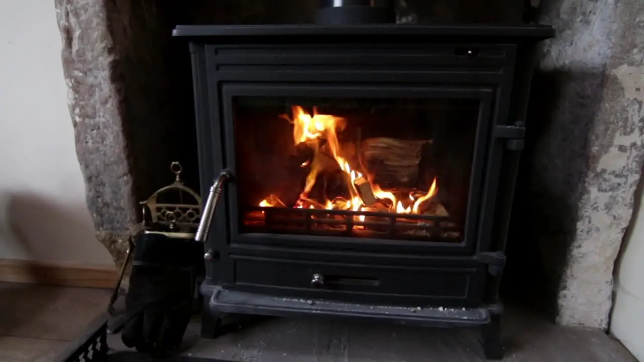 Wood stove has bright glow of fire after being lit and blazing in the burner